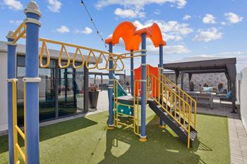 A playground with a slide and a climbing frame.